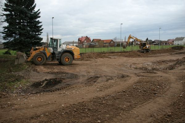 Radlader und Bagger verteilen Erdaushub auf dem Gelände