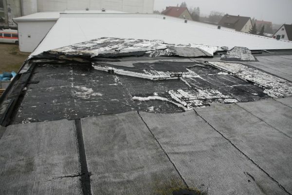 Schaden mit Blickwinkel zum Turm. Ausgerissene Styroporplatten deutlich sichtbar.