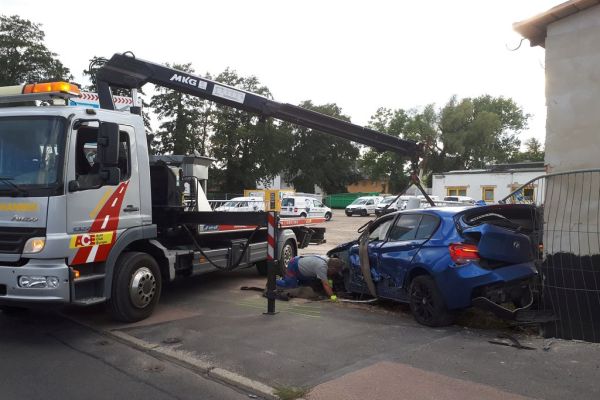 Auto wird vom Abschlepper aus der Mauer gehoben.